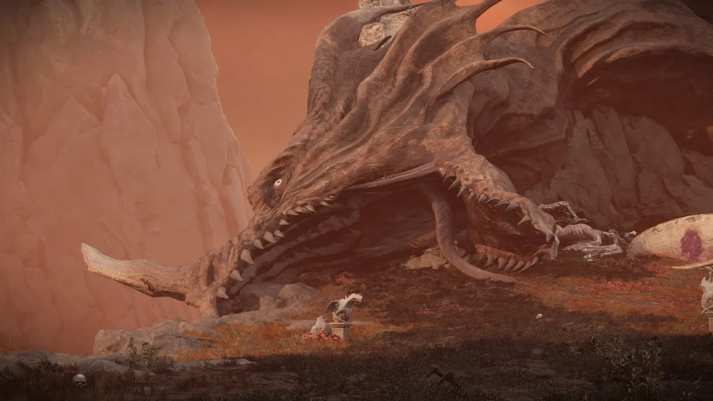 The Grand Altar of Dragon Communion in Shadow of the Erdtree: the enormous corpse of a dragon lying open-jawed against reddish rock, with a small dragon statue on a stone pedestal in the foreground.