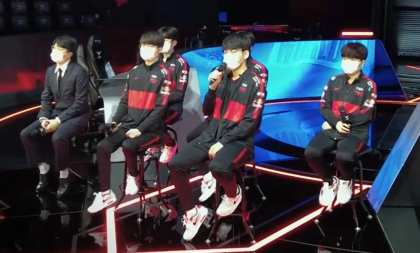 T1 players seated together at a press event, wearing team jerseys, during World Championship media day.