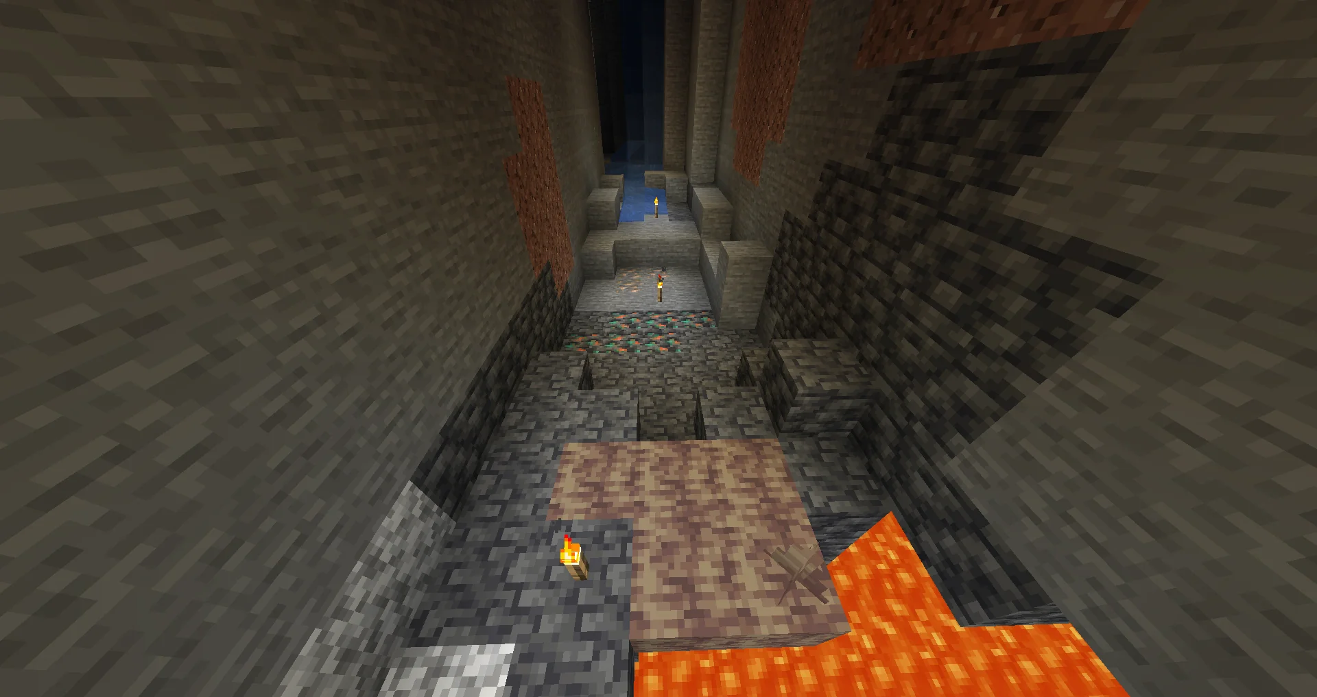 Copper ore veins with their orange flecks exposed in the walls of a ravine, lit by torches above a pool of lava.