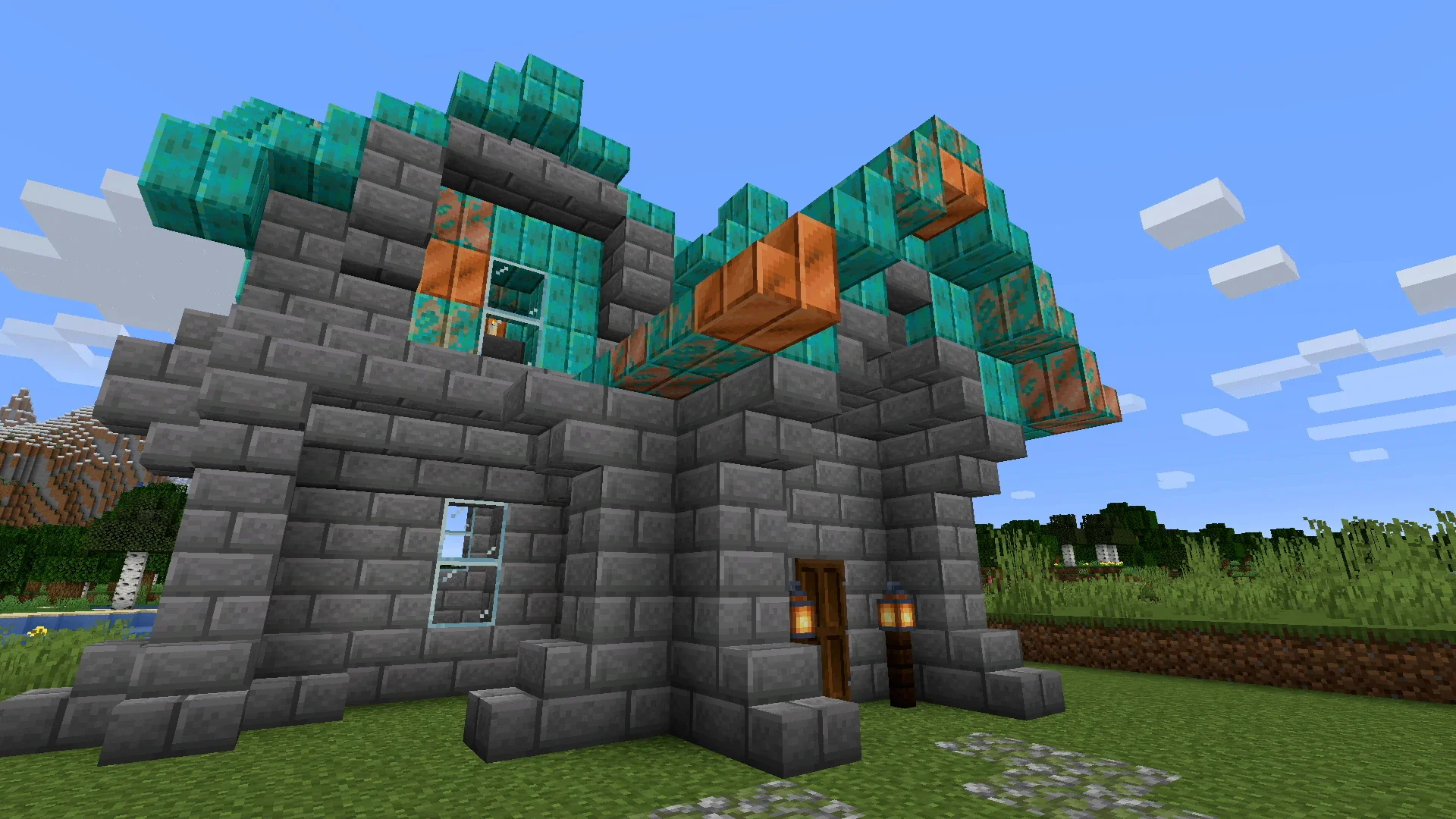 A stone-brick house roofed with copper blocks at mixed oxidation stages, bright orange unoxidized copper sitting right next to teal weathered and oxidized blocks.