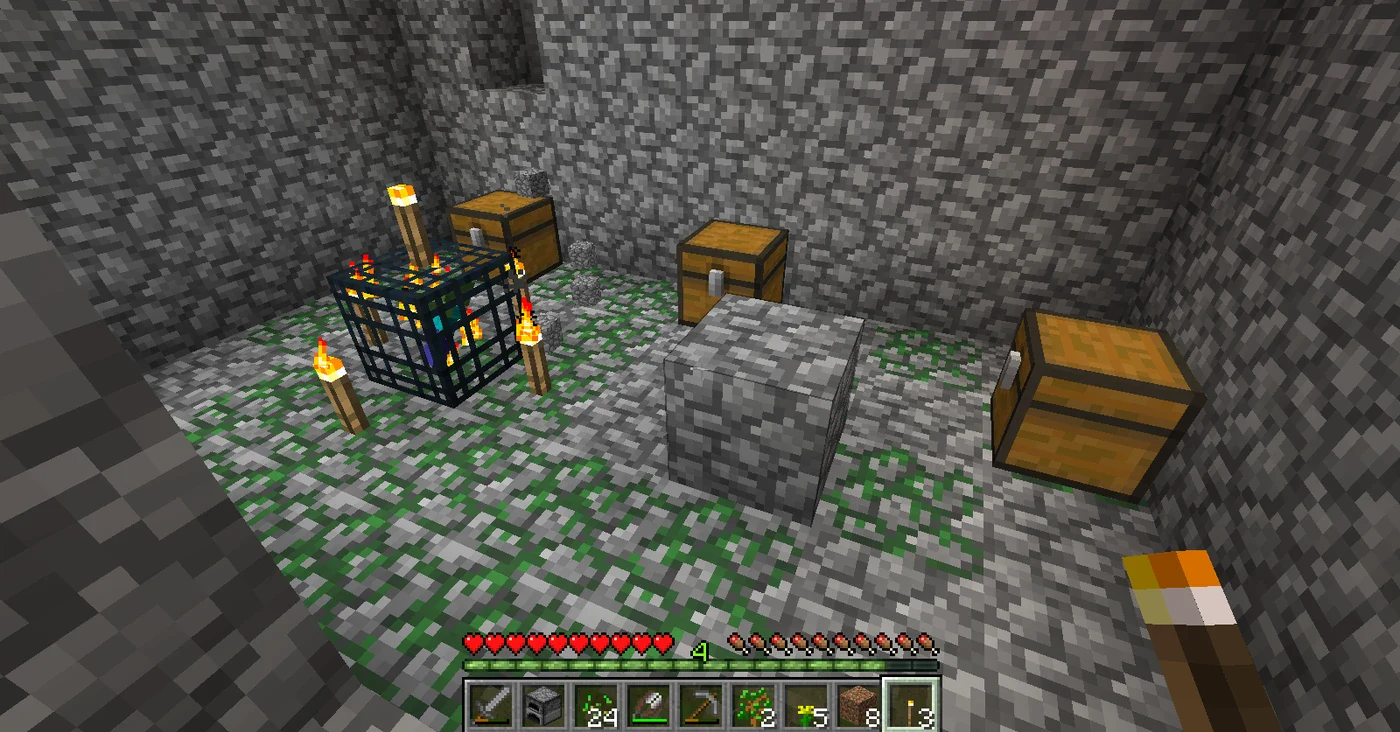 A Minecraft monster room with a spawner in the center flanked by two loot chests on a mossy cobblestone floor