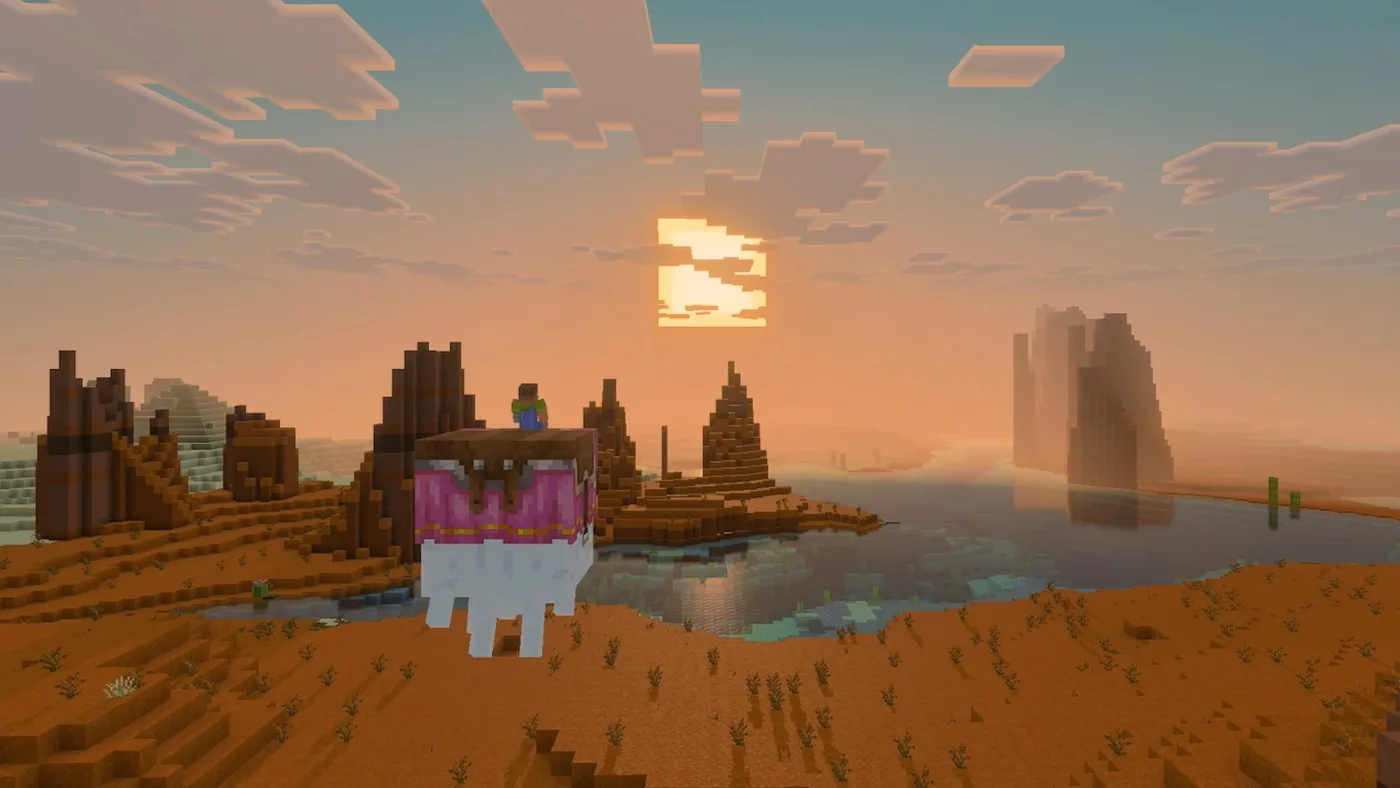 A Minecraft player riding a happy ghast in a pink harness over a badlands biome at sunset, with red terracotta spires on the left, a lake reflecting the low sun in the middle and hazy rock pillars in the distance.