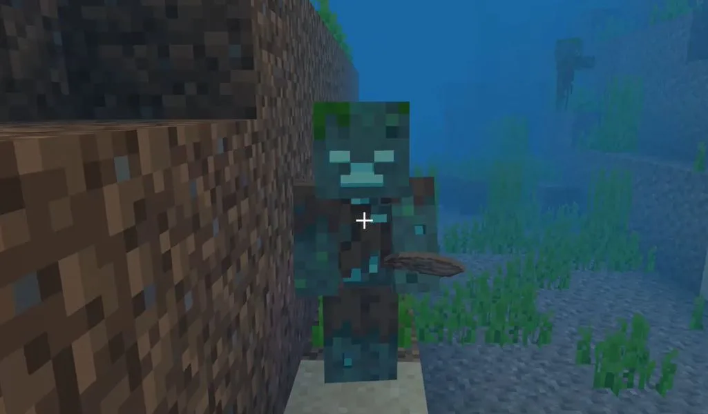 A drowned underwater in Minecraft holding a nautilus shell in its offhand, the guaranteed drop used to craft a conduit.