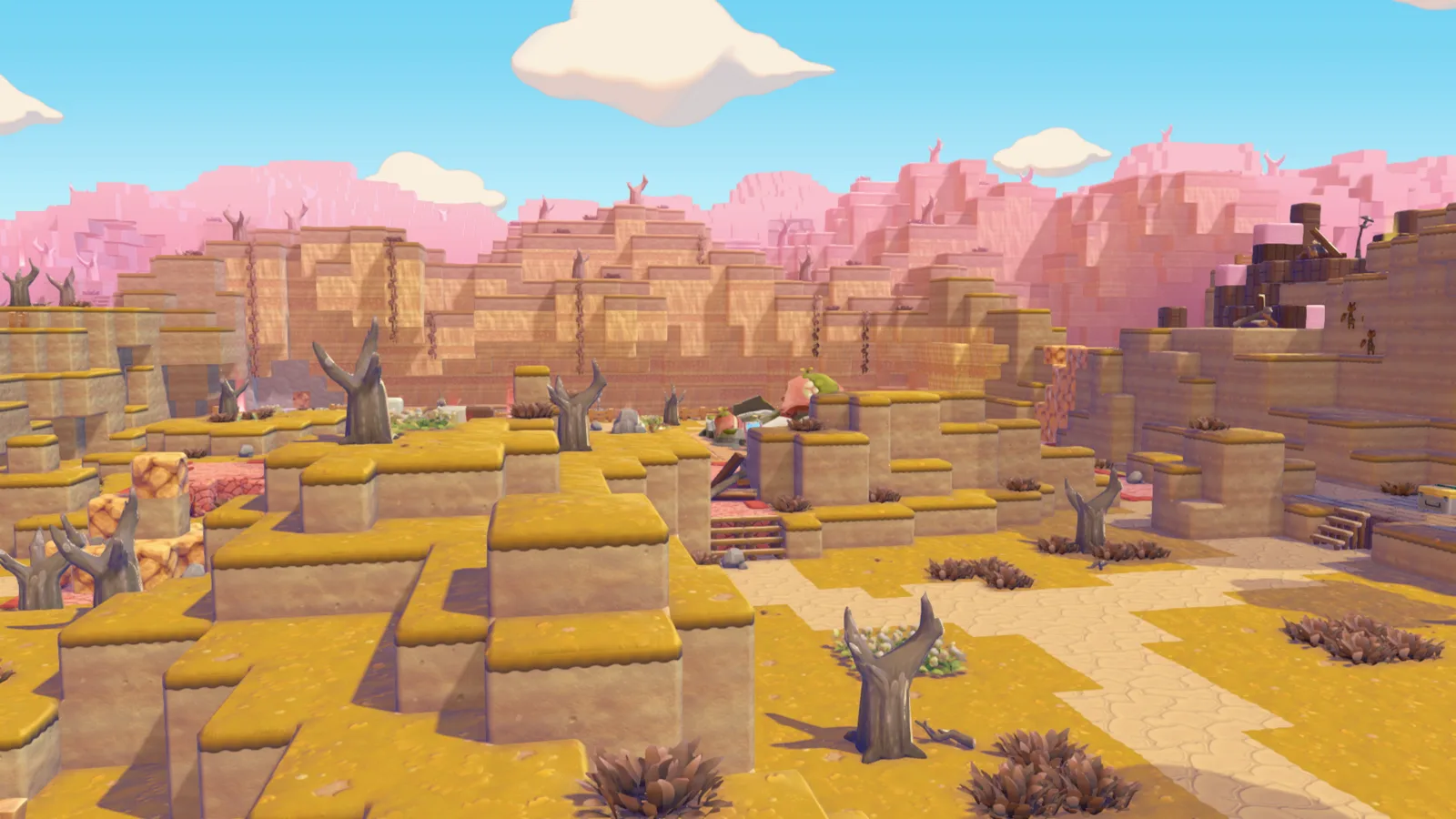 The Withered Wasteland in Pokemon Pokopia: a parched, blocky canyon of dried yellow grass, dead trees, and pink rock mesas under a blue sky.