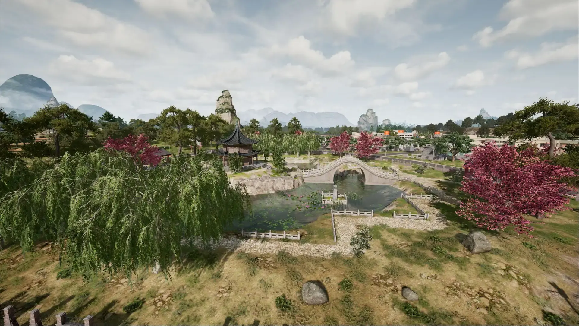 A traditional Rondo village with a stone arch bridge over a lake, willow trees and cherry blossoms, with karst mountains rising in the background.