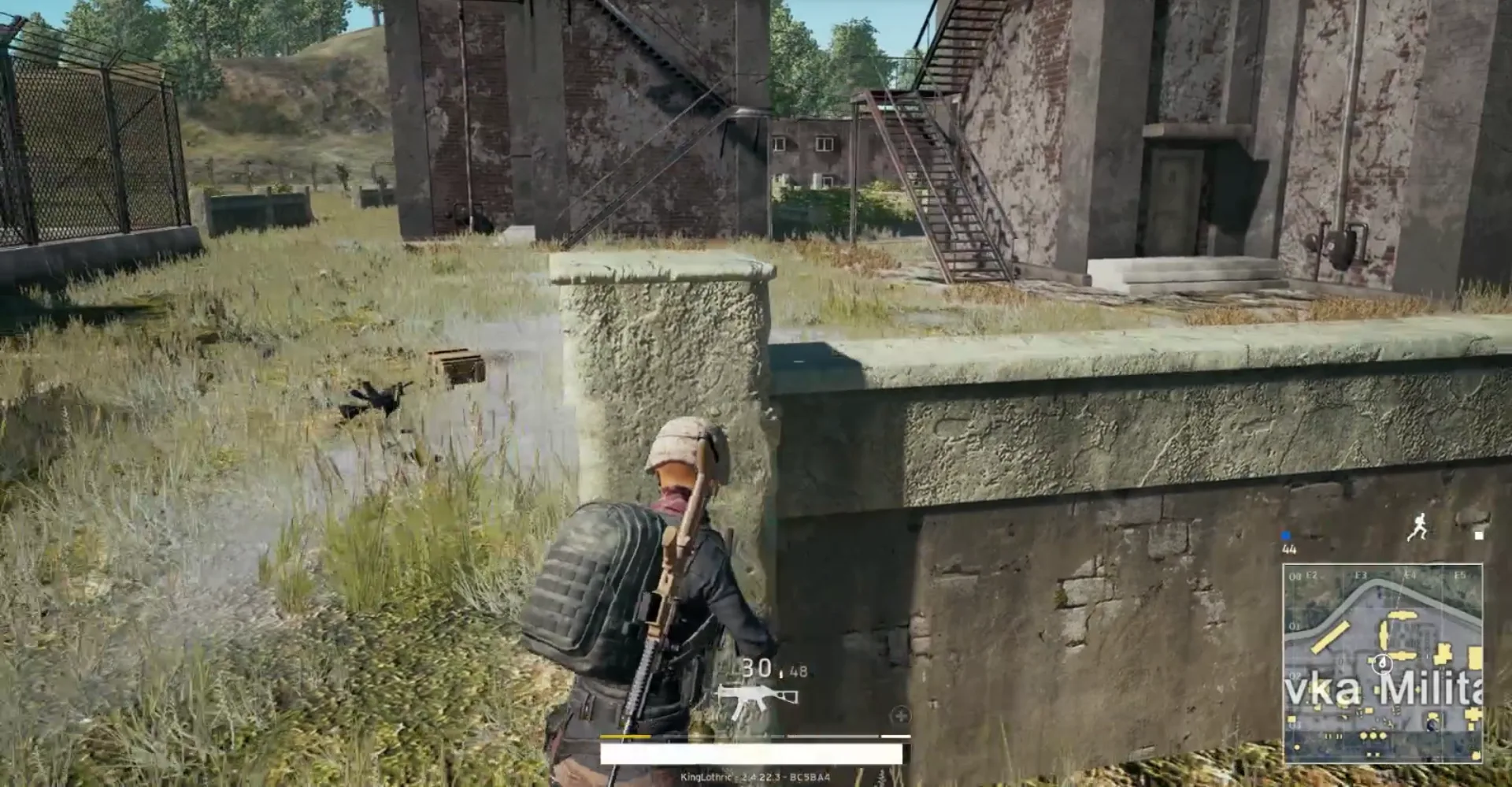 A PUBG player holding tight to a wall for cover — the third party approaches under cover and holds an angle rather than charging into the open.