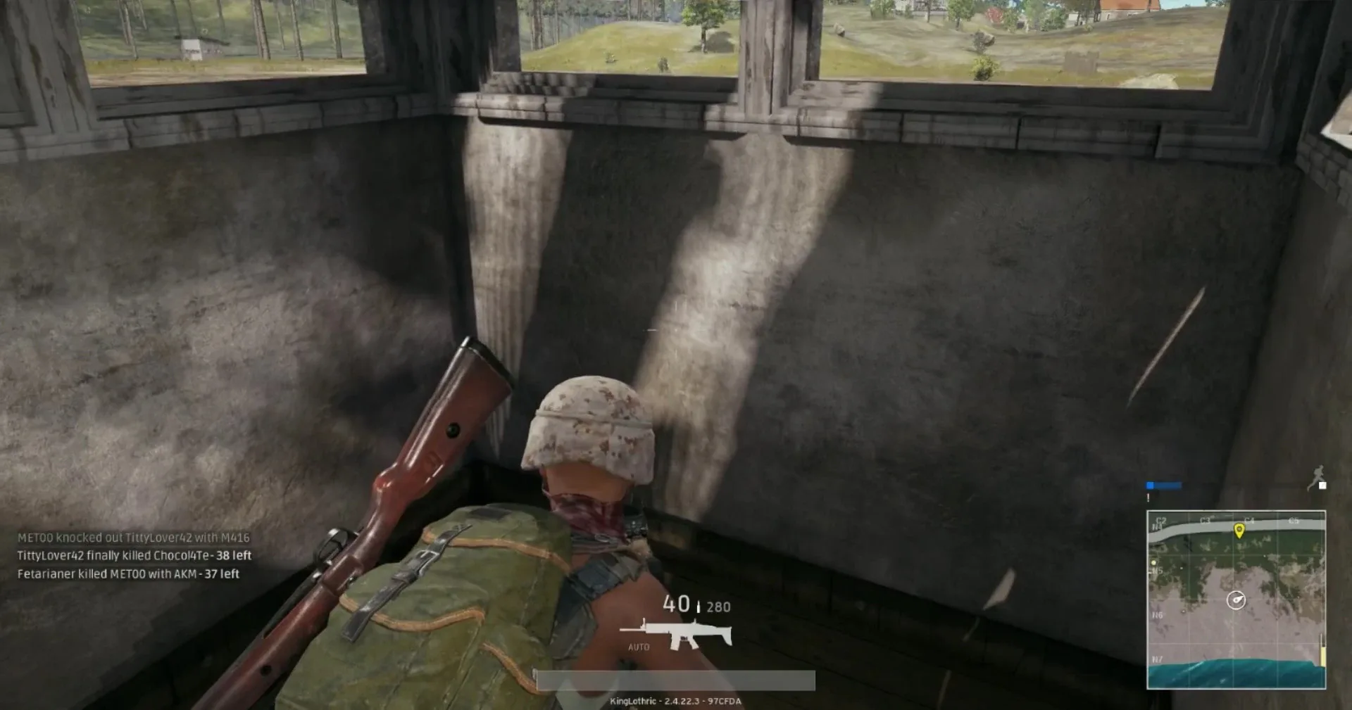 A PUBG player holding position beside cover, watching a distant firefight — the moment before a third party punishes whoever wins.