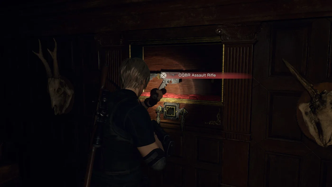Leon in the Resident Evil 4 remake castle reaching for the framed CQBR Assault Rifle inside a Square Lock Box, flanked by two mounted animal skulls.