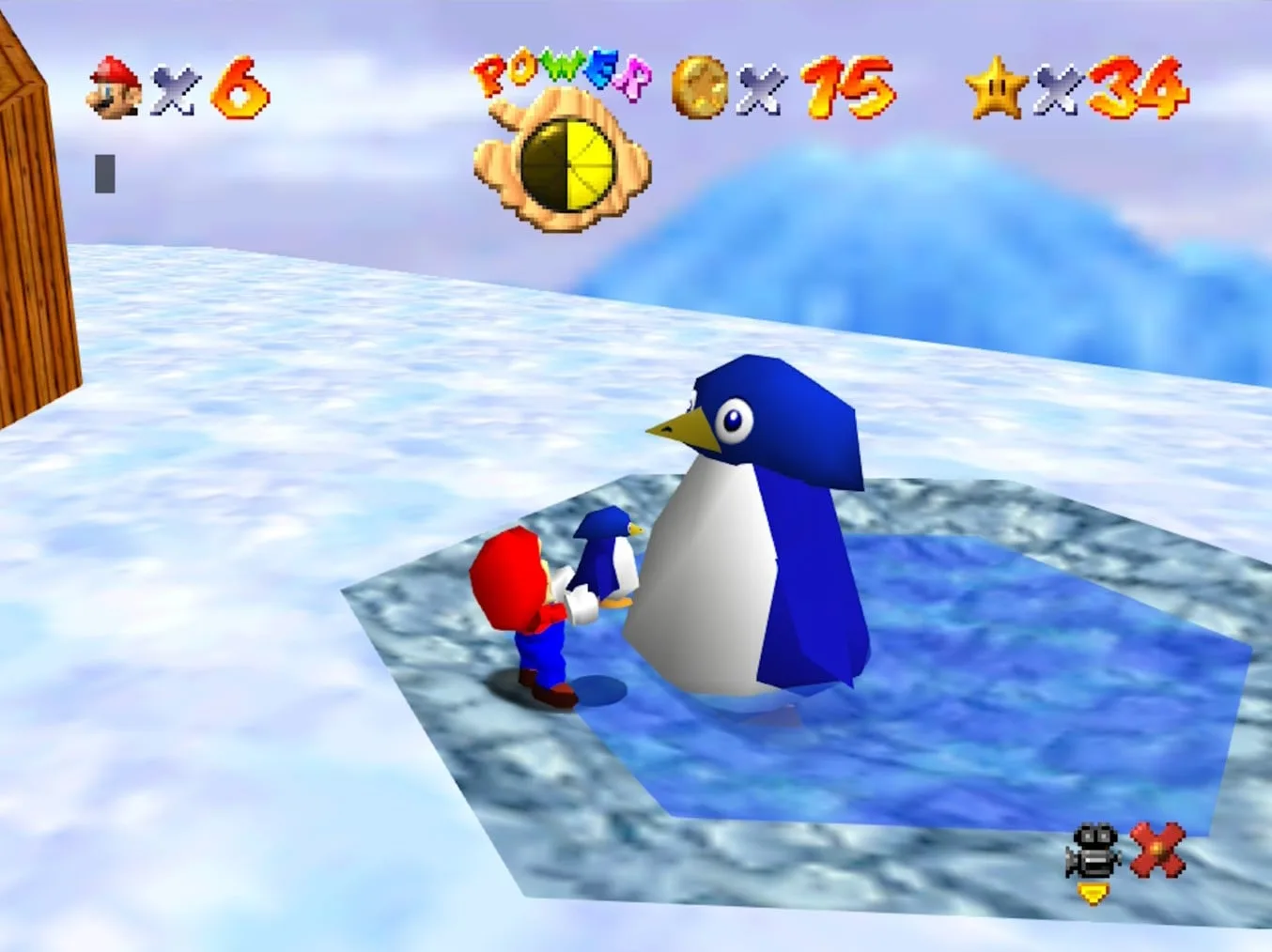 Mario carrying the baby penguin Tuxie down to the Mother Penguin at the base of Cool, Cool Mountain in Super Mario 64.