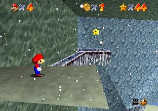 Mario on the last ledge in Cool, Cool Mountain in Super Mario 64, with the Wall Kicks Will Work Power Star waiting across the narrow ice bridge ahead of him.