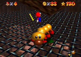 Mario jumping above Wiggler on the wire-mesh floor of the cave inside Tiny-Huge Island's mountain.