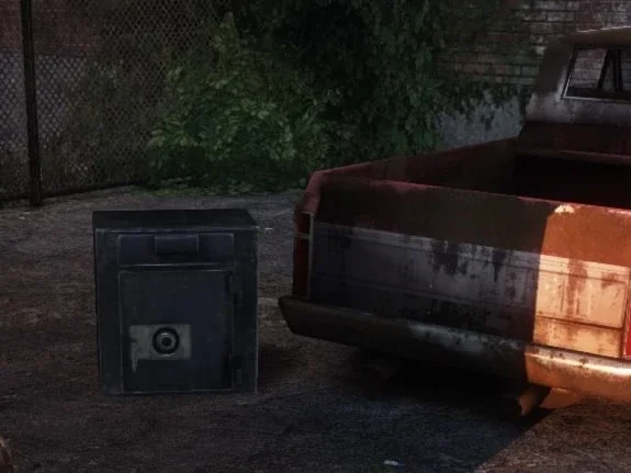 The combination safe sitting beside a rusted pickup truck in Bill's Town in the first The Last of Us.