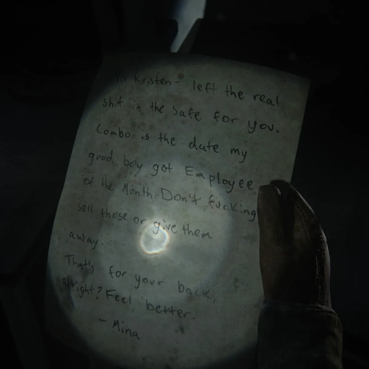 Mina's handwritten Good boy combo note held up in flashlight beam, telling Kristen the safe combo is the date her good boy got Employee of the Month.
