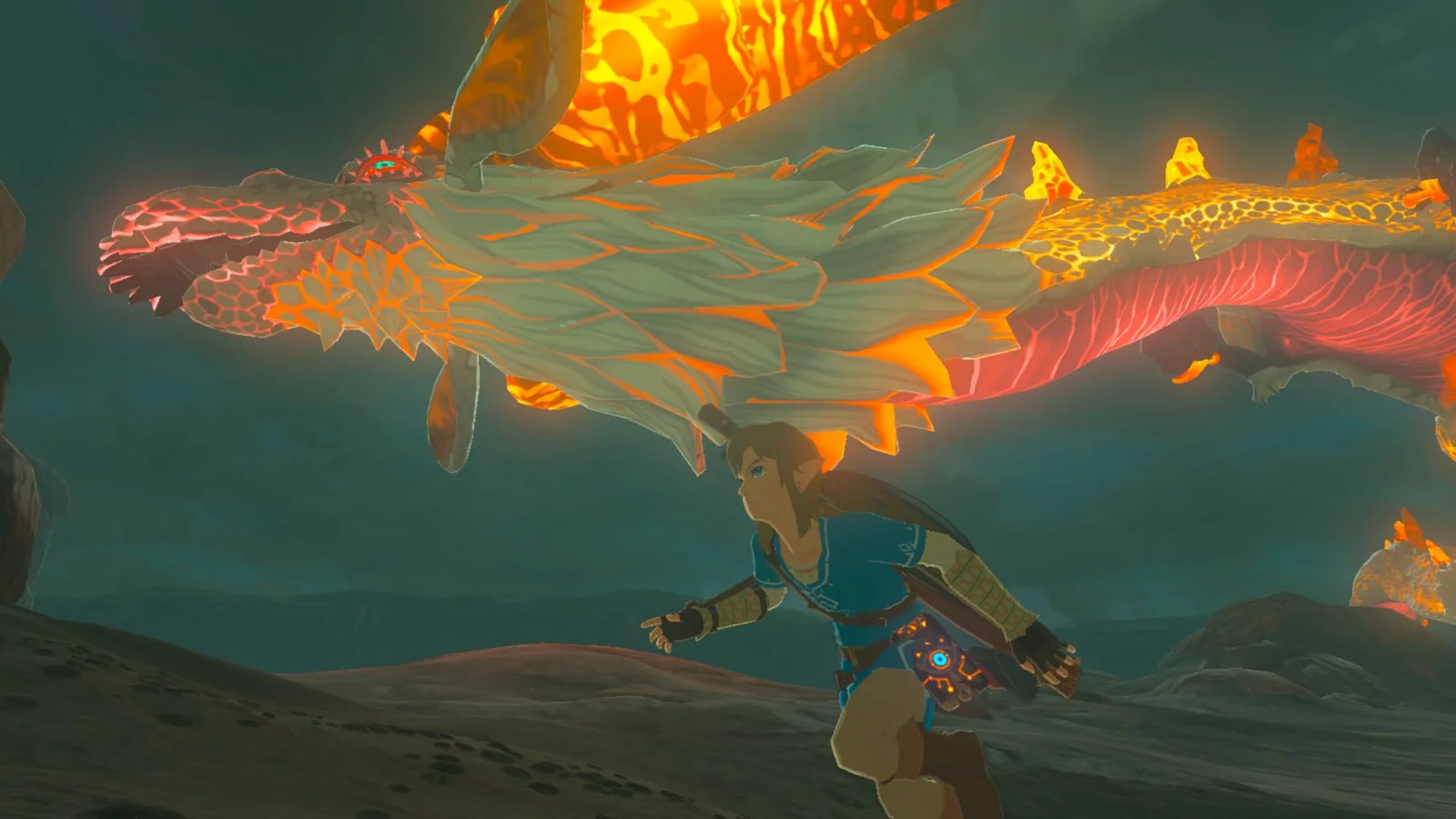 Link sprinting across dark rocky ground in Breath of the Wild as Dinraal, wreathed in flame and glowing orange, flies low directly overhead.