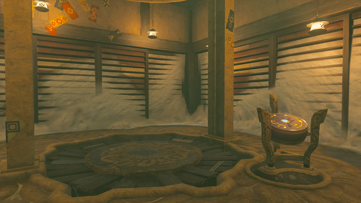 The inside of the Gerudo Highlands Skyview Tower: a round launch pad sunk into a wooden floor at the centre, the terminal on a carved wooden stand to the right with a glowing blue eye on its face, and pale drifts piled against the slatted walls under hanging lanterns.